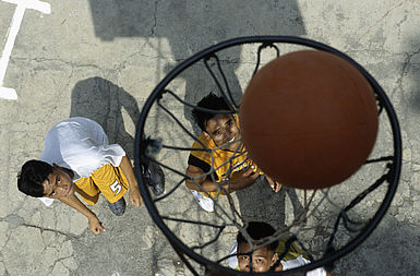 Jungen spielen gemeinsam Basketball