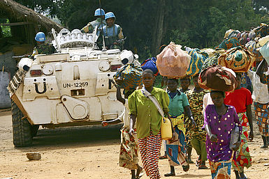 Soldaten der UNO begleiten Menschen auf der Flucht